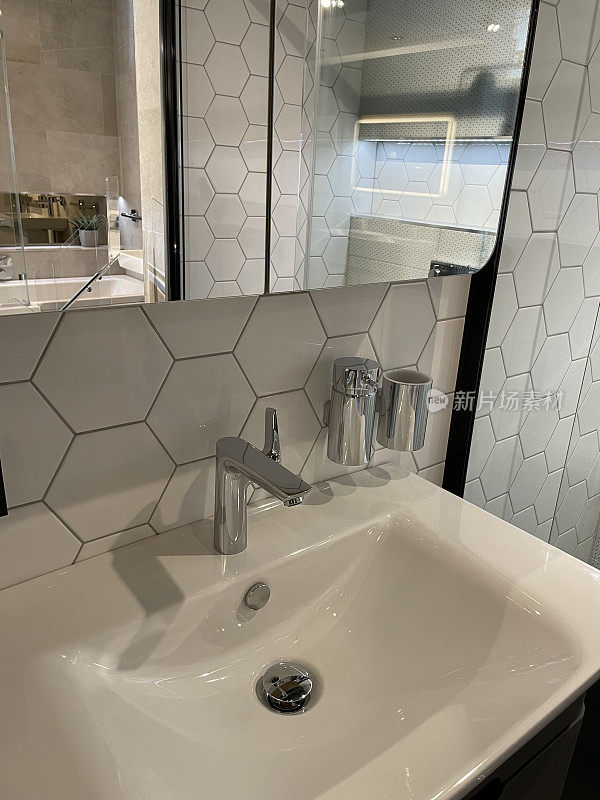 近照现代浴室与铬，单一的杠杆整体搅拌机水龙头白色陶瓷水槽，皂液器，小，白色六角形墙砖