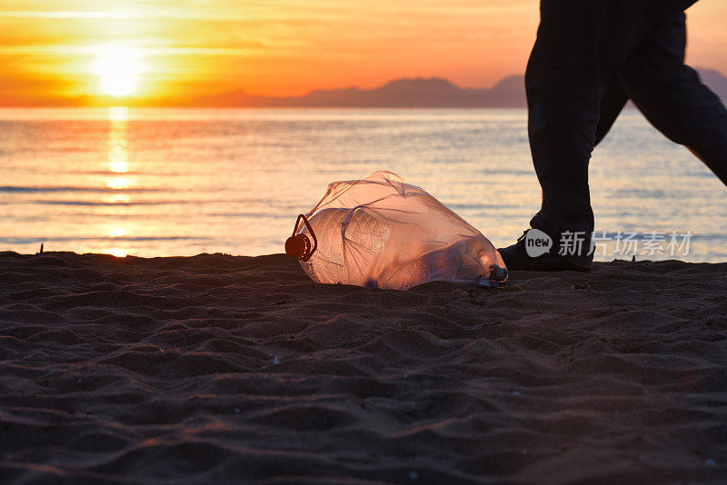 日落时分海滩上的塑料垃圾