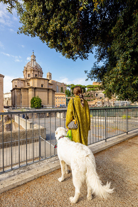 一个女人带着她的狗在罗马市中心散步