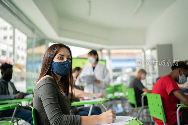 一名年轻女学生在教室里的肖像——戴着口罩