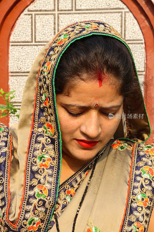 印度教的特写图像，穿着传统服装的印度妇女，黄金，刺绣的纱丽，穿着sindoor在头发分开，bindi在前额，头部特写，重点在前景