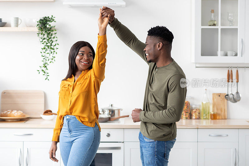 爱的年轻非洲裔美国夫妇一起跳舞在厨房室内