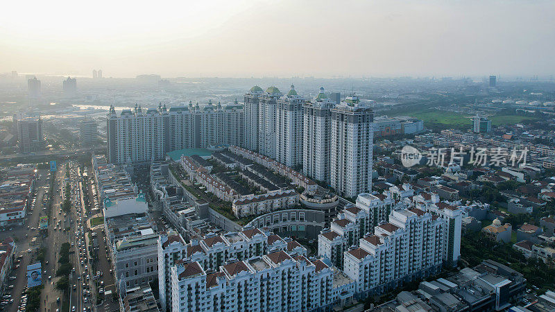 城市新绿城市景观鸟瞰图。城市景观的住宅区与现代公寓建筑日落时与噪音云。