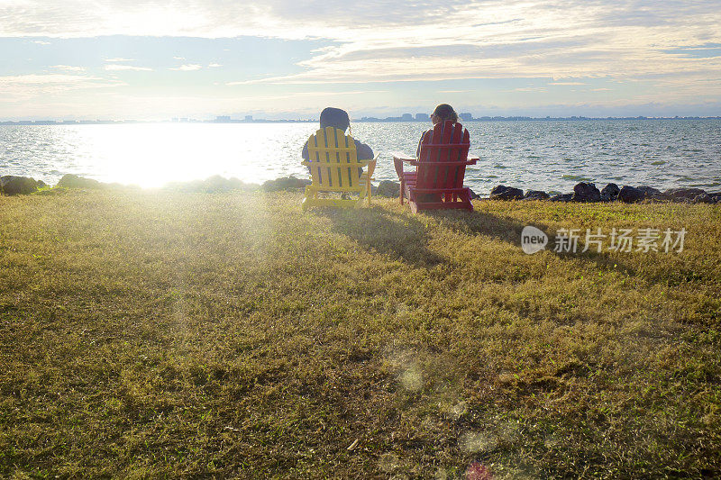 两个幸福的女人坐在海边看风景