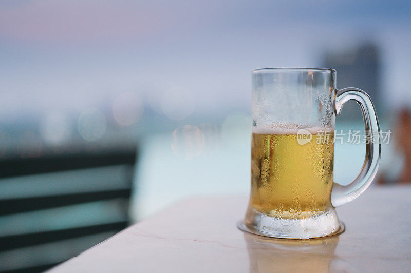 享受放松周五的一杯啤酒在曼谷的屋顶酒吧与游泳池的观点