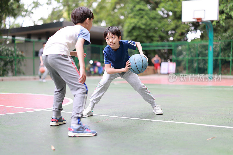 两个男孩在外面打篮球