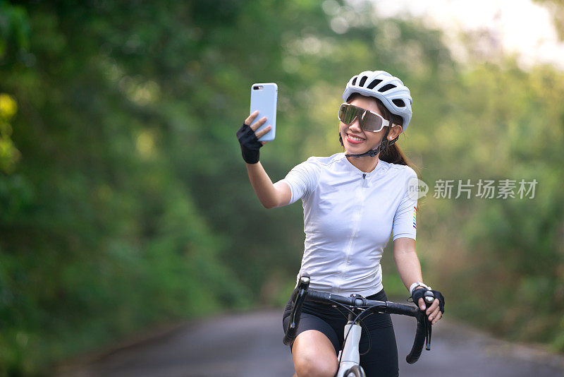 女性自行车骑行自拍女性社交群体与智能手机在骑自行车锻炼和放松在山上的道路或街道的健康生活
