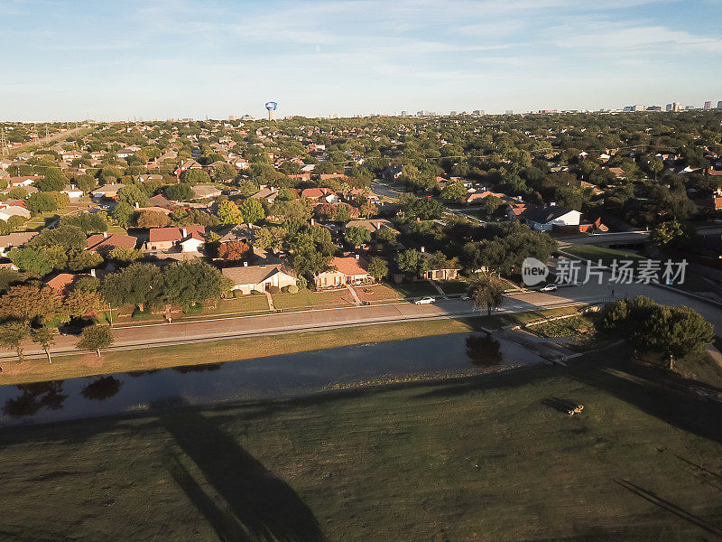 鸟瞰一排独栋住宅，背景是达拉斯市中心的建筑，附近的卡罗顿，得克萨斯州，美国