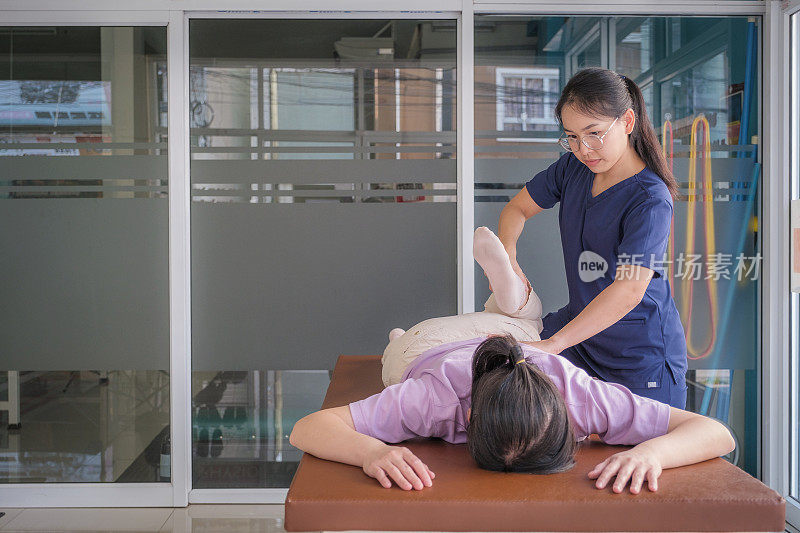 女医生或理疗师，为前来就诊的女病人提供脊椎按摩和腿部调整治疗