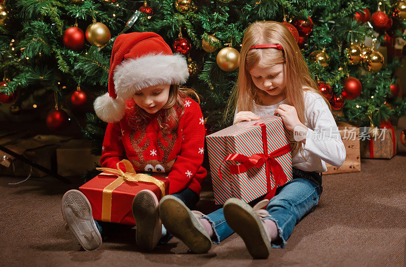 孩子们打开圣诞老人在圣诞树下找到的珍贵礼物
