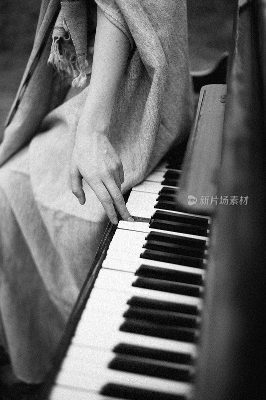 一个女人的手在秋天的田野里弹奏着钢琴
