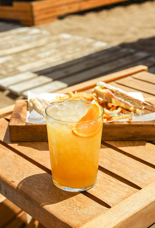 阳光明媚的日子，橙色鸡尾酒沙滩小吃和三明治