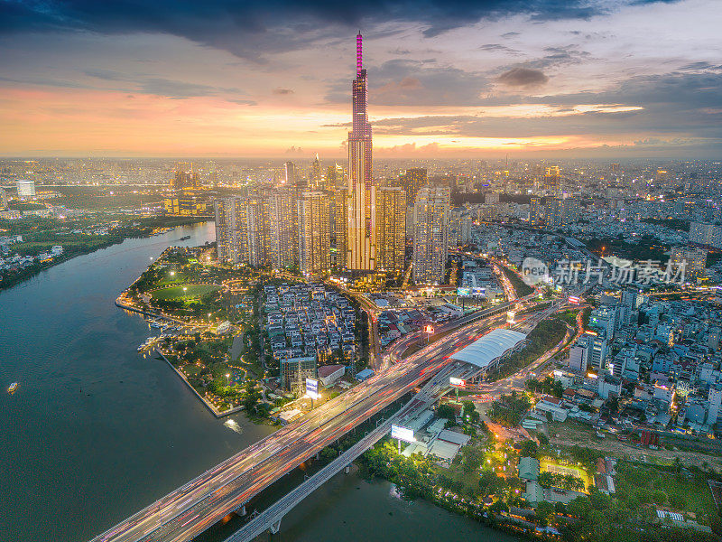 从空中俯瞰81号地标的日落景观——一幢超高的摩天大楼和西贡大桥，西贡河沿岸的发展在光线下十分流畅