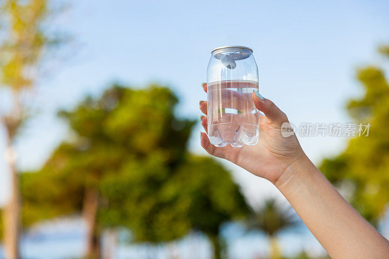 面目全非的女子拿着装着水的塑料罐，以大自然为背景