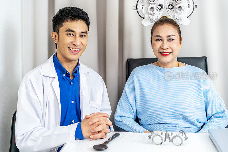 年轻的亚洲男眼科医生在眼科诊所做眼科检查，高级妇女在眼镜店用验光机检查她的眼睛