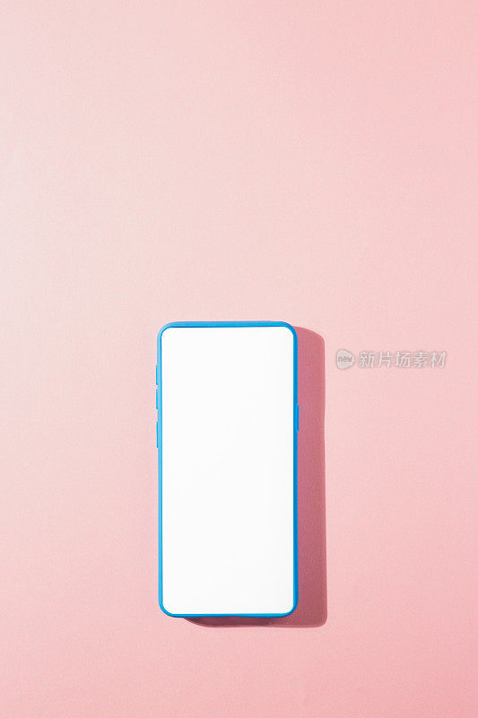 垂直拍摄的蓝色智能手机，粉色背景上的空白屏幕