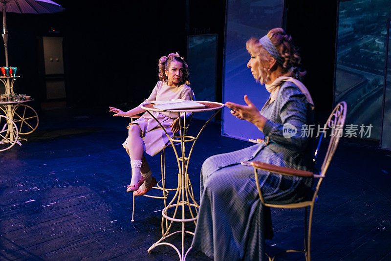 不同年龄的女演员晚上在剧院的舞台上读剧本