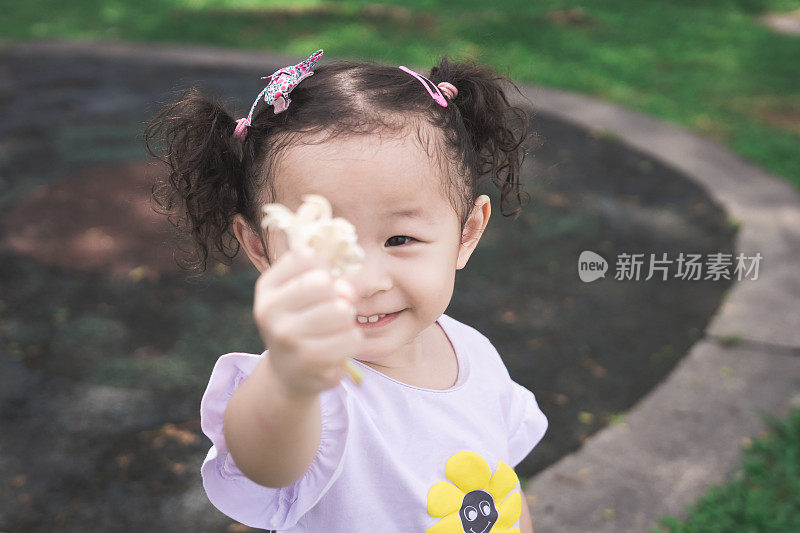 女婴抱着一束白花