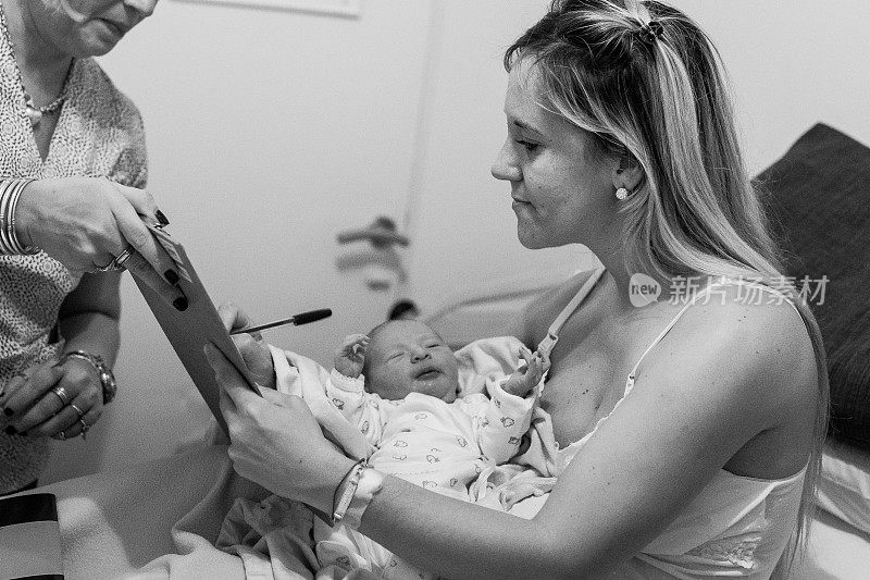 母亲和护士在医院填写新生婴儿的文件