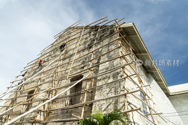 菲律宾宿务，一名菲律宾工人在竹脚手架上重新装饰Oslob教堂的端墙。