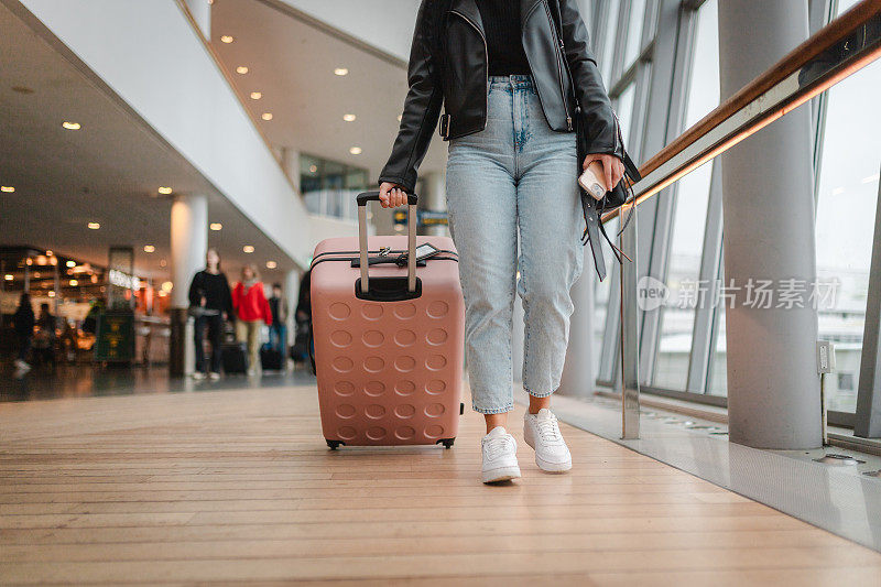 一位女士在机场拖着行李的特写镜头