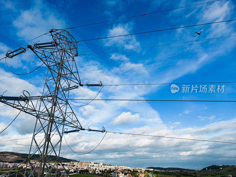 航拍图片，背景是天空和一架飞机经过葡萄牙中部地区的高压塔