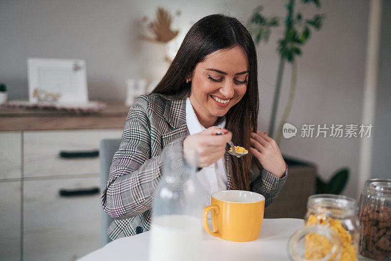 商务女性享用玉米片加牛奶，享用健康早餐