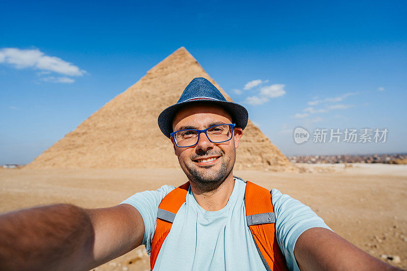 在开罗吉萨金字塔前自拍的年轻人