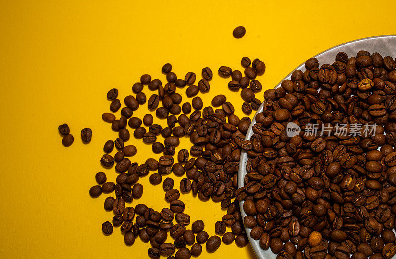 咖啡豆被隔离在黄色背景上。快乐的最小咖啡主题与复制空间