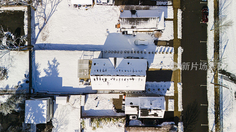 阳光明媚的雪屋顶排列在新泽西州麦迪逊住宅区的道路上