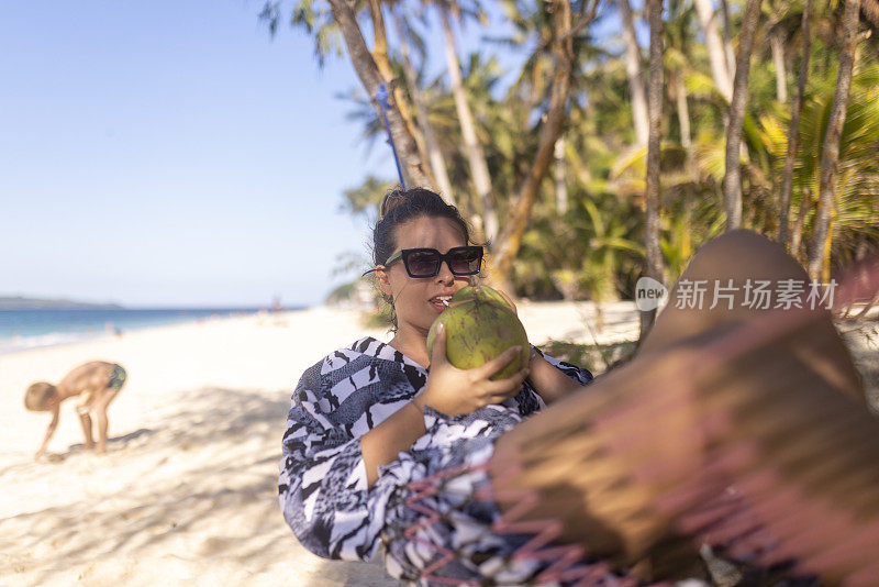 一位身着夏装的美女喝着柚子鸡尾酒