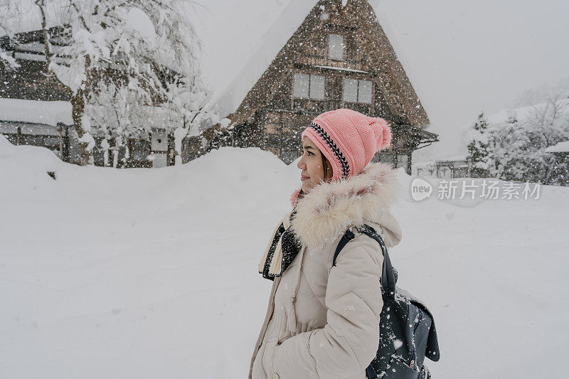 美丽的女游客享受他们的旅行白川古村在日本的冬天厚雪