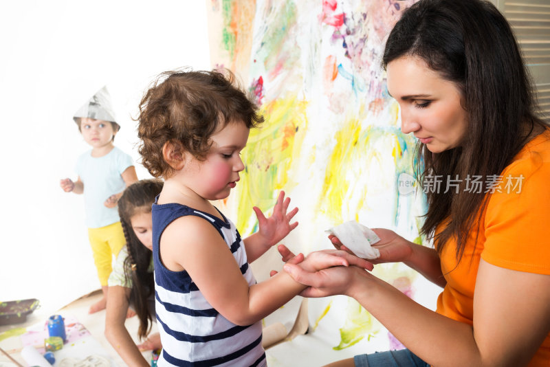 小孩子在纸墙上画颜料