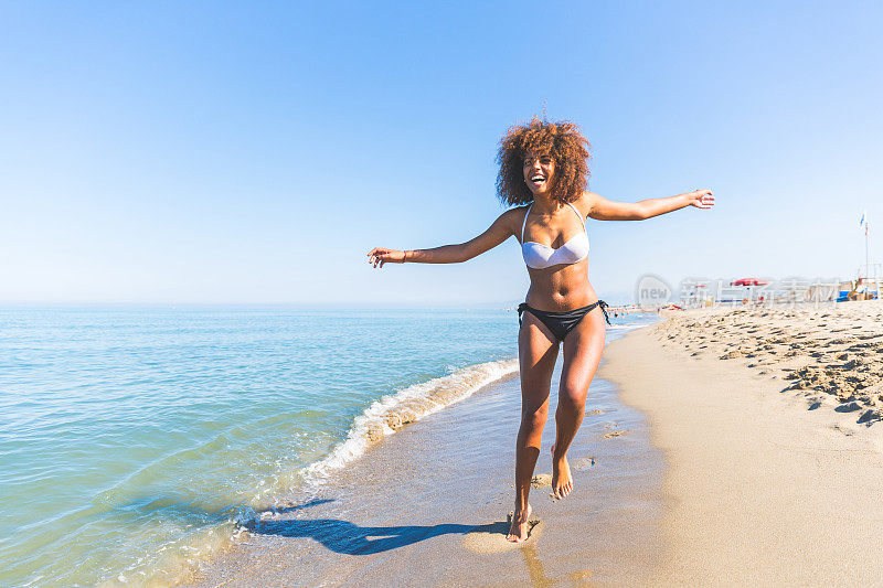 年轻的黑人妇女在海边玩