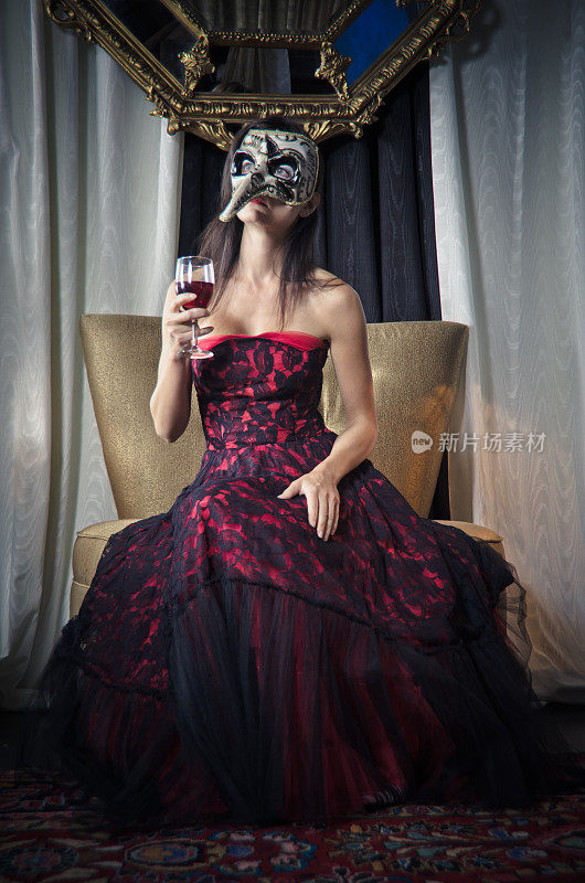 威尼斯面具下的美女喝红酒