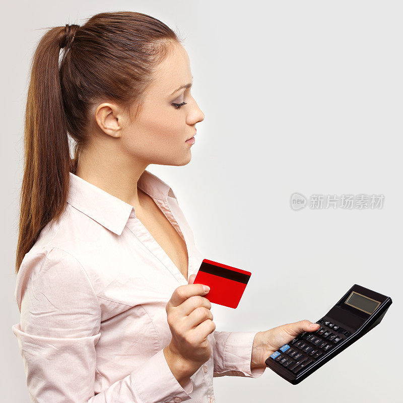 年轻女子拿着信用卡在想。
