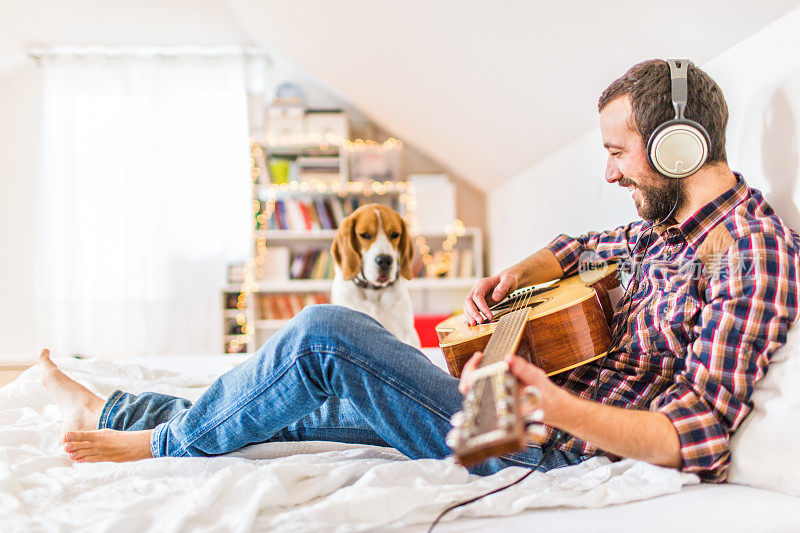 一个人在给他的狗弹吉他
