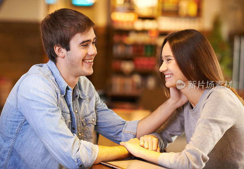 一对深情的年轻夫妇在咖啡店里使用数码平板电脑