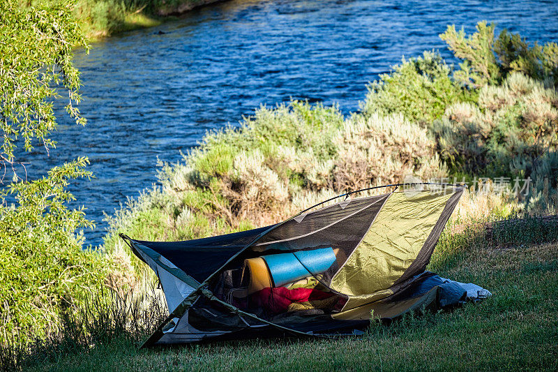 在风景如画的河流位置倾覆的帐篷