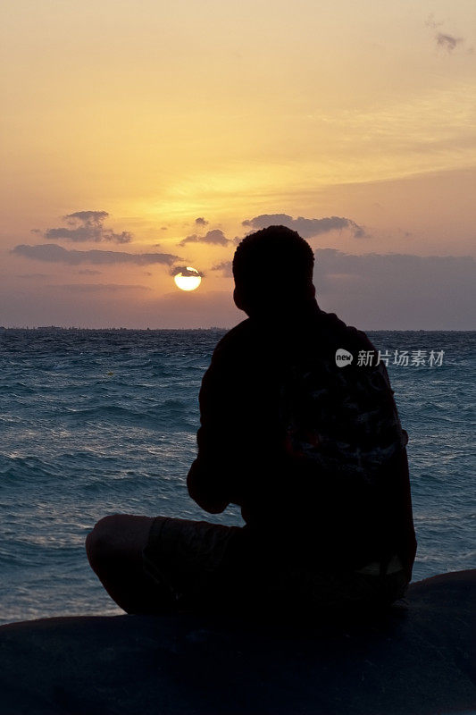 海洋落日下的人的剪影