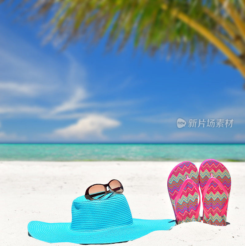 夏日草帽，太阳镜和人字拖在热带海滩上