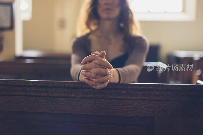 年轻女子在教堂祈祷