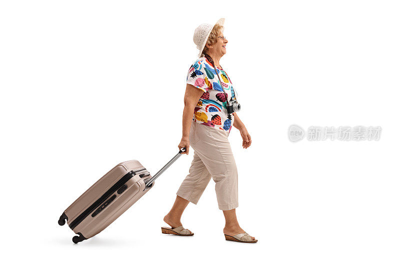 年老的游客一边走一边提着行李箱