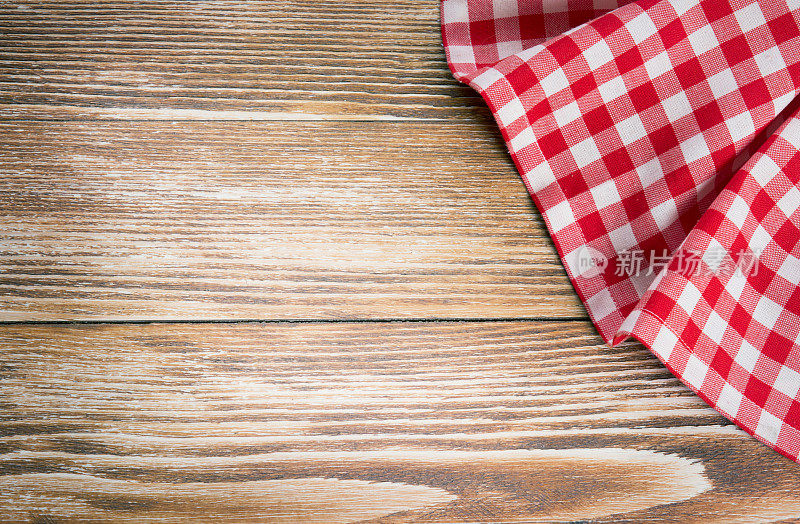 木制背景上的红色野餐布。餐巾，桌布，铺在旧木头上。