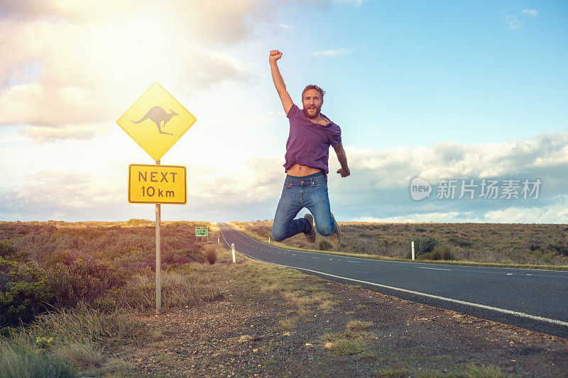欢呼的年轻人跳在半空中的道路，澳大利亚