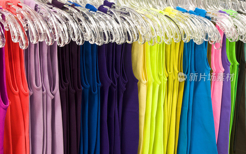 彩色t恤放在商店展示架上的衣架上