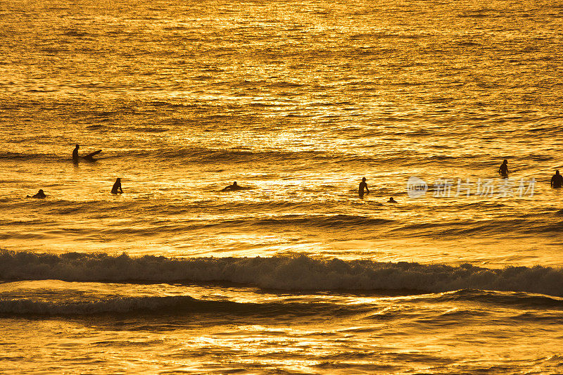 日出时太平洋上的冲浪者