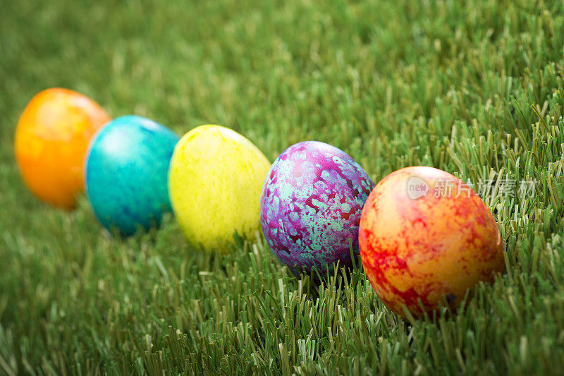 绿色草地上五颜六色的斑点复活节彩蛋