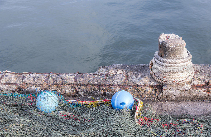旧码头的渔网、浮标和系柱，
