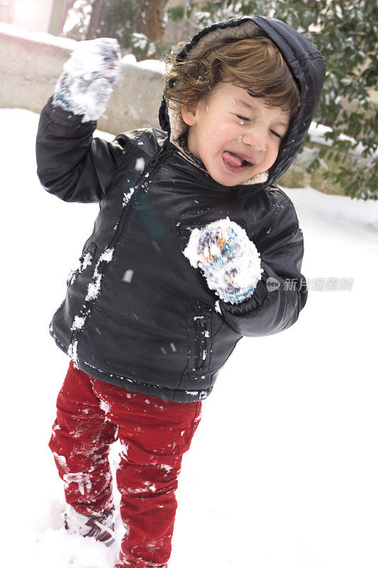 小男孩在冬天的公园里抓雪花